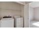 Laundry room with a white washer and dryer and storage shelves; adjoining room visible at 1574 Olympia Cir # 305, Castle Rock, CO 80104