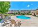 Community kidney-shaped pool with lounge chairs on a concrete patio and townhomes in background at 1574 Olympia Cir # 305, Castle Rock, CO 80104