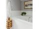 Bright bathroom featuring a soaking tub, gray walls, and a wooden accent table at 3410 W 31St Ave, Denver, CO 80211