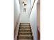 Bright staircase featuring wooden rails and carpeted steps leading to the upper level at 3410 W 31St Ave, Denver, CO 80211