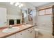 Bright bathroom with dual sinks, tub/shower combo, and white cabinets at 10535 Cottoneaster Way, Parker, CO 80134