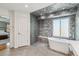 Well-lit bathroom with unique black and white tiling, a glass shower and soaking tub at 10535 Cottoneaster Way, Parker, CO 80134