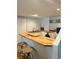 Modern kitchen featuring butcher block countertops, bar seating, and white cabinetry at 10535 Cottoneaster Way, Parker, CO 80134