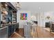 Elegant wet bar with granite countertops, glass shelves and seating adjacent to a fireplace at 579 Madison St, Denver, CO 80206