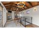 Cozy bonus room with wood-beam ceiling, stone fireplace, and wrought iron railing at 579 Madison St, Denver, CO 80206