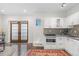 Bright kitchen featuring white cabinets, modern appliances, tile backsplash, and access to outdoor space through charming French doors at 579 Madison St, Denver, CO 80206