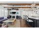 Inviting living space featuring a fireplace, exposed beams, and an open layout to the kitchen area at 579 Madison St, Denver, CO 80206