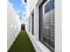 Narrow side yard with artificial grass, a white wall, and access gate at 579 Madison St, Denver, CO 80206