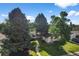 Aerial view of charming single-story home with large trees and well-maintained lawn at 7120 S Sheridan Ct, Littleton, CO 80128