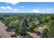 Scenic aerial view of a home with a well-manicured lawn and mature trees at 7120 S Sheridan Ct, Littleton, CO 80128