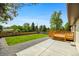 Backyard with grass, wood deck, gravel, and concrete patio at 7120 S Sheridan Ct, Littleton, CO 80128