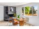 Bright dining area featuring a brick fireplace, wood table, and large window with natural light at 7120 S Sheridan Ct, Littleton, CO 80128