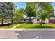 Charming home boasts lush lawn, mature trees, and a welcoming walkway, complemented by modern exterior at 7120 S Sheridan Ct, Littleton, CO 80128