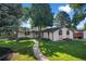 Charming single-story home with a well-manicured front yard, mature trees, and inviting walkway at 7120 S Sheridan Ct, Littleton, CO 80128
