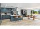 Updated kitchen with a gray island and adjacent dining area featuring a brick fireplace and natural light at 7120 S Sheridan Ct, Littleton, CO 80128