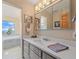 Bright bathroom featuring a double mirror and vanity with a soaking tub and scenic outdoor views at 13288 Elsie Rd, Conifer, CO 80433