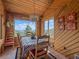 Cozy dining room with beautiful mountain views, wood walls, and a decorative chandelier for a warm ambiance at 13288 Elsie Rd, Conifer, CO 80433