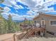 Mountain house with a large deck, an outdoor dining set, gorgeous views, and steps at 13288 Elsie Rd, Conifer, CO 80433