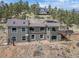 Hillside home featuring a shingled exterior, multiple windows, and an attached deck with scenic views at 13288 Elsie Rd, Conifer, CO 80433