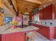 Well-lit kitchen features red cabinetry, granite countertops, and tile flooring at 13288 Elsie Rd, Conifer, CO 80433