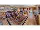 Open-concept living room featuring hardwood floors, leather furniture, and views into the kitchen at 13288 Elsie Rd, Conifer, CO 80433