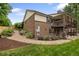 Exterior view of brick home with wood porch, lush landscaping and stone pathway at 5292 W Fair Dr, Littleton, CO 80123