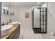 Stylish bathroom featuring double sinks, a walk-in shower with black trim, and marble floors at 5292 W Fair Dr, Littleton, CO 80123