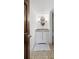 Small bathroom with patterned tile, white cabinet, and a framed mirror at 5292 W Fair Dr, Littleton, CO 80123