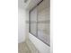 Clean bathroom featuring a tub with sliding glass doors and neutral tile at 5292 W Fair Dr, Littleton, CO 80123