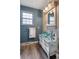 Unique bathroom featuring a vanity repurposed from an antique dresser, blue glass bowl sink, and rustic decor at 5292 W Fair Dr, Littleton, CO 80123