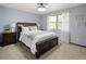 Comfortable bedroom with a dark wood bed frame, soft carpet, and natural light at 5292 W Fair Dr, Littleton, CO 80123