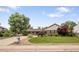 Charming ranch home with a well-manicured lawn, mature trees, and a neatly paved driveway at 5292 W Fair Dr, Littleton, CO 80123