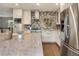 Modern kitchen featuring stainless steel appliances, tile backsplash, and white cabinetry at 5292 W Fair Dr, Littleton, CO 80123