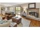 Cozy living room featuring a brick fireplace, hardwood floors, and access to an outdoor deck at 5292 W Fair Dr, Littleton, CO 80123