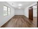 Spacious living room features wood-look flooring, bright light, and convenient access through a wooden door at 5292 W Fair Dr, Littleton, CO 80123