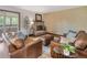 Cozy living room with leather furniture, fireplace and an adjacent outdoor patio at 5292 W Fair Dr, Littleton, CO 80123
