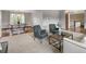 Open-concept living area with a dining space, stylish seating, and hardwood floors beyond carpet at 5292 W Fair Dr, Littleton, CO 80123
