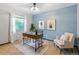 Bright home office with modern desk, comfortable chair, and natural light from a large window at 5292 W Fair Dr, Littleton, CO 80123