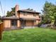 Large backyard with deck, covered patio, stairs, and a spacious lawn at 591 Nome St, Aurora, CO 80010