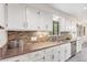 Bright kitchen featuring white cabinets, stainless steel appliances, and a brown backsplash with double basin sink at 591 Nome St, Aurora, CO 80010