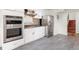 Modern kitchen with stainless steel appliances, white cabinets, and gray tile flooring provides a stylish space at 591 Nome St, Aurora, CO 80010