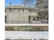 Front view of a two story townhome with snow covered landscaping at 1825 Kendall St # 101, Lakewood, CO 80214