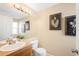 Cozy half bathroom featuring a decorative mirror, framed artwork, and earth-toned walls at 9654 W Elmhurst Pl, Littleton, CO 80128