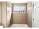Clean and modern bathroom featuring a shower over bath with neutral tiling at 9654 W Elmhurst Pl, Littleton, CO 80128