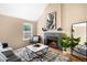 Cozy living room featuring a charming fireplace, neutral decor, and bright windows at 9654 W Elmhurst Pl, Littleton, CO 80128