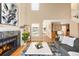 Inviting living room featuring a stone fireplace, lots of natural light, and wood flooring at 9654 W Elmhurst Pl, Littleton, CO 80128