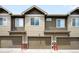 Exterior shot of townhome garages with neutral siding and bronze garage doors at 15546 W 64Th Loop # C, Arvada, CO 80007