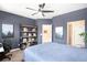 Comfortable main bedroom with dark walls, a ceiling fan, and shelving to display books and decor at 15546 W 64Th Loop # C, Arvada, CO 80007