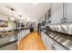 Spacious kitchen with stainless steel appliances, granite countertops, white cabinetry and hardwood floors at 1827 N Grant St # 1000, Denver, CO 80203