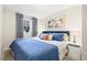 Bedroom featuring a blue bed, soft curtains, modern art, and neutral-toned walls at 3649 N Garfield St, Denver, CO 80205